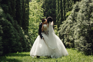 Groom catches luxuriant bride in his hugs