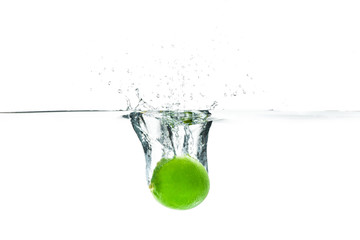 Fresh lime dropped into the water with water splash on a white b