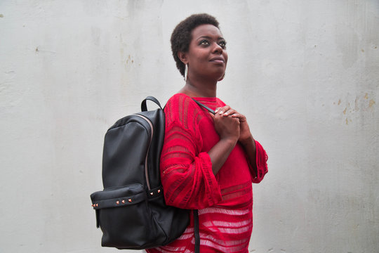 Black Woman With Short Hair Holding A Purse On White Texture Background