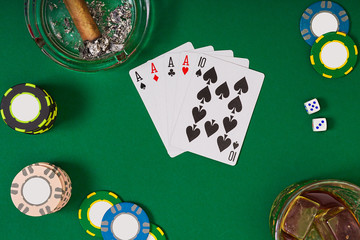 Set to playing poker with cards and chips on green table, top view