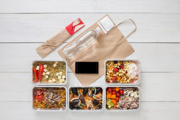 Healthy food online order in boxes, top view at wood