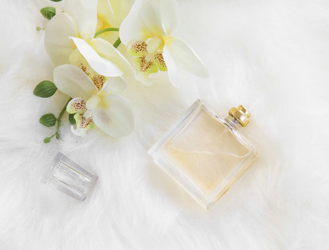 Floral perfume bottle with yellow orhicd, overhead shot
