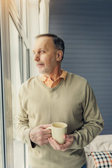 Happy male pensioner relaxing at home
