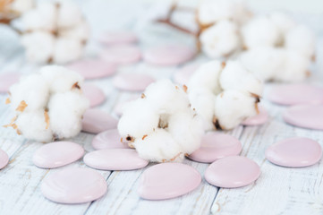 Delicate white cotton flowers and pebble stones on a wooden board