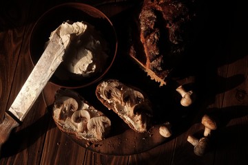 Bread and toasts with cream cheese and mushrooms on wood background