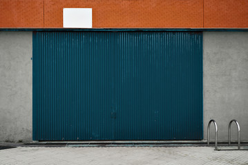 View on the gates of big warehouse, architecture garage mockup facade with small bike parking on...