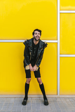 Young man in front of yellow geometric wall