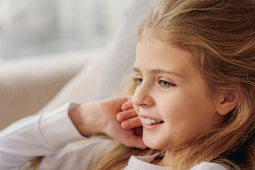 Happy kid lying on sofa at home