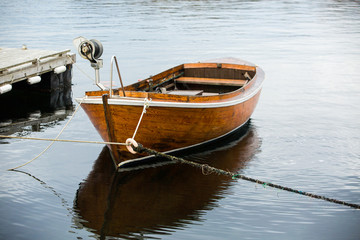 Traditional wooden boat at the pier is tied rope