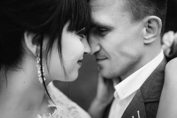 Wedding. Wedding day. Close-up of couple. Bride and groom look at each other and smiling. Bride and groom at wedding day. Black and white. Romantic and love concept