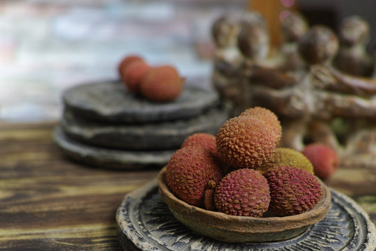 Lychees on wooden background - exotic and tropical fruit