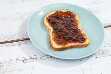 Typical Dutch apple syrup called Appelstroop on bread on wooden background