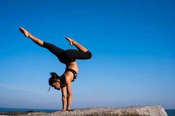 Asian woman practice Yoga on the beach blue sky