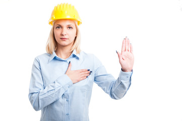 Blonde lady engineer taking oath with hand up
