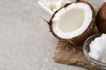 Coconut with coconut oil in jar on wooden background
