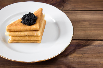 traditional russian Pancakes on plate with black caviar