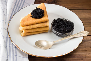 traditional russian Pancakes on plate with black caviar