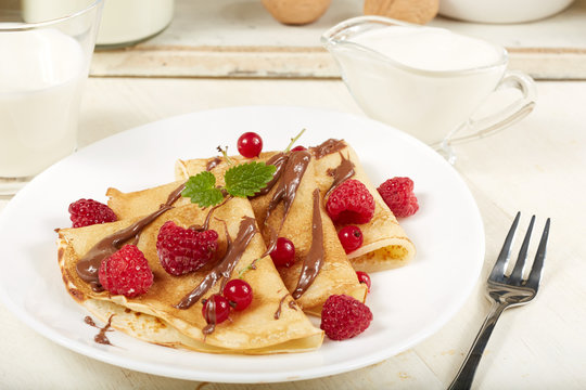 Pancakes with raspberry, red currant and chocolate. Dessert. Traditional Russian cuisine.