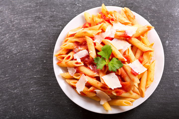 plate of penne pasta with tomato sauce and parmesan