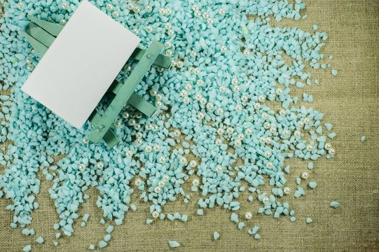 Blue easel with white paper for inscriptions on the crumbled blue gravel