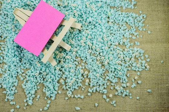 White easel with pink paper for inscriptions on the crumbled blue gravel.