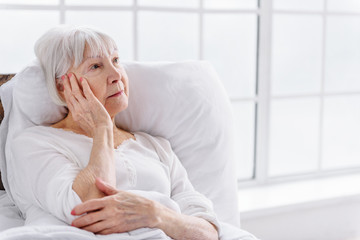 Worried patient reclining in cot at clinic