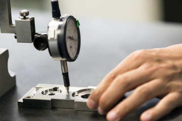technician use dial guage measure part thickness