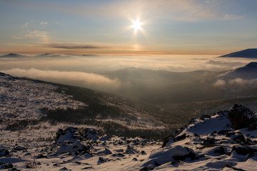 WInter Hiking: Sunny dawn in the mountains above the clouds