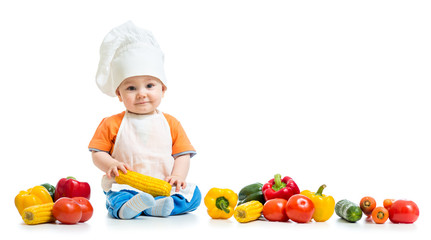 Smiling chef kid boy with vegetables isolated on white background