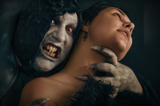 Ancient monster vampire demon bites a woman neck. Halloween fant