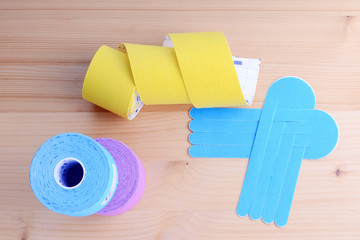 Special physio tape rolls on wooden background, closeup.