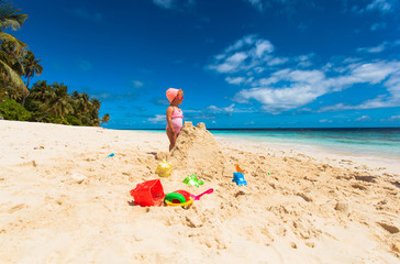 little girl play with sand on beach