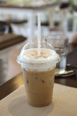 ice coffee in a plastic glass on the table.