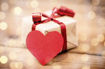 close up of gift box and heart shaped note on wood