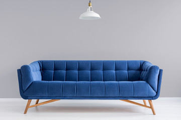 Grey interior with stylish upholstered sofa - obrazy, fototapety, plakaty