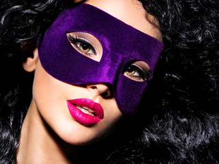 Beautiful  woman with black hairs and violet theatre mask on fac