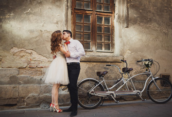 Fototapeta na wymiar The couple in love kissing near building