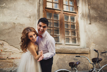 The happinest couple in love stands near bicycle