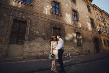 The happinest couple in love stands near bicycle