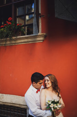 The charming  couple in love embracing near building