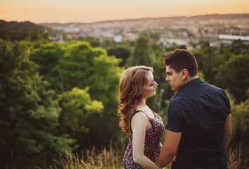 The lovely couple in love embracing on the field