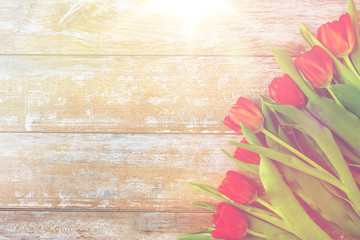 close up of red tulips on wooden background