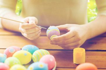 close up of woman hands coloring easter eggs