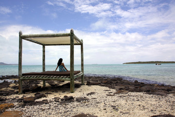 Eine Frau auf einem Strandbett am Strand von Mauritius 