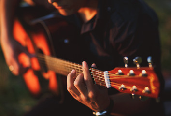 Fototapeta premium The boy plays on guitar