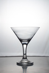 Transparent glass cup with a pouring bubbling cold fresh water with bubbles and drops