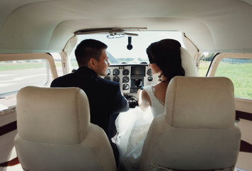 beautiful and young newlyweds sitting in helicopter