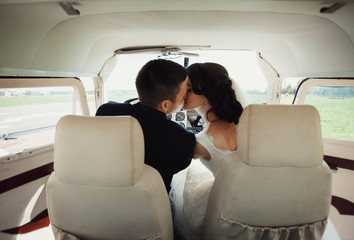 beautiful and young newlyweds kissing in helicopter