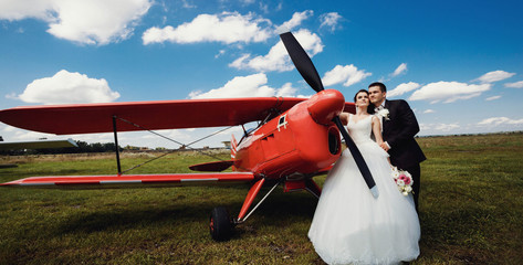 beautiful and young newlyweds standing near helicopter