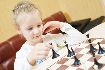 Child girl playing chess game